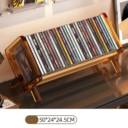 CD holder with various CDs on an amber acrylic stand on a reflective surface.