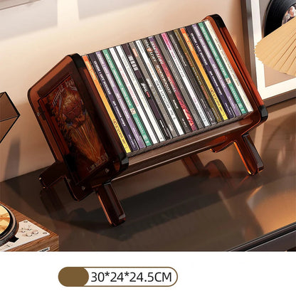 Medium size CD holder with various CDs on an amber acrylic stand on a reflective surface.