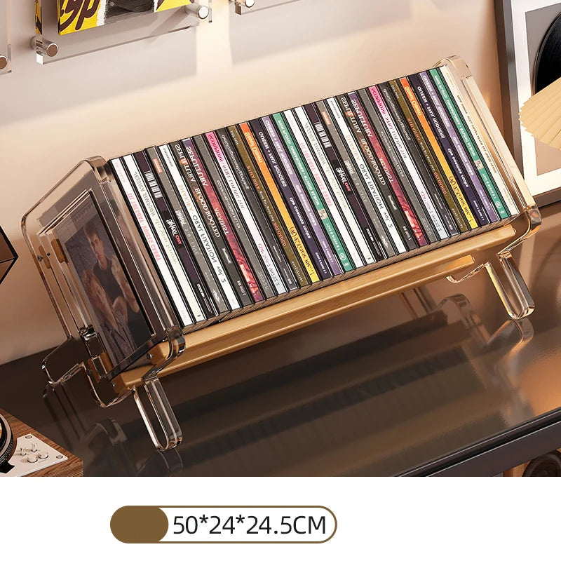 CD holder with transparent stand displaying CDs on a reflective shelf.