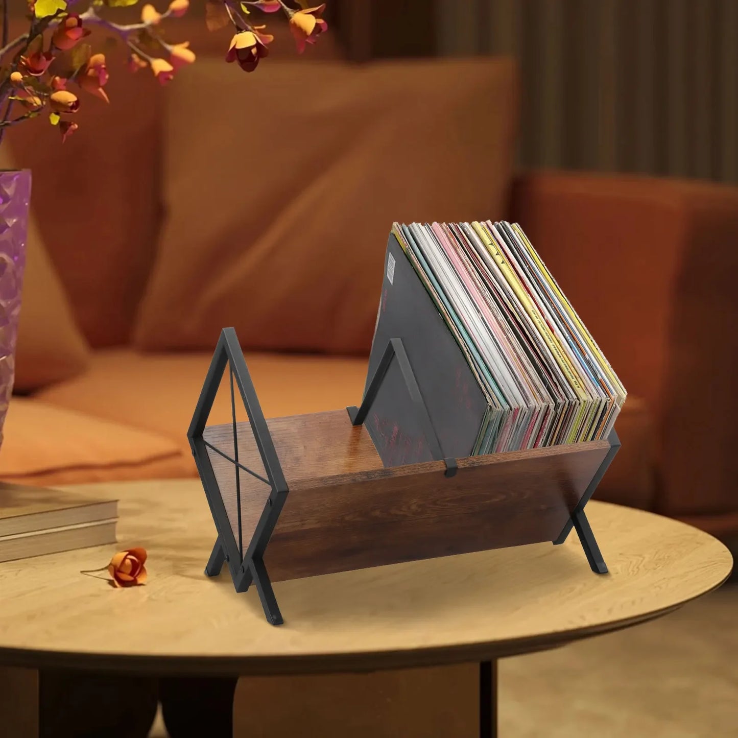 Wooden record holder with vinyl records on a table in a cozy living room setting.